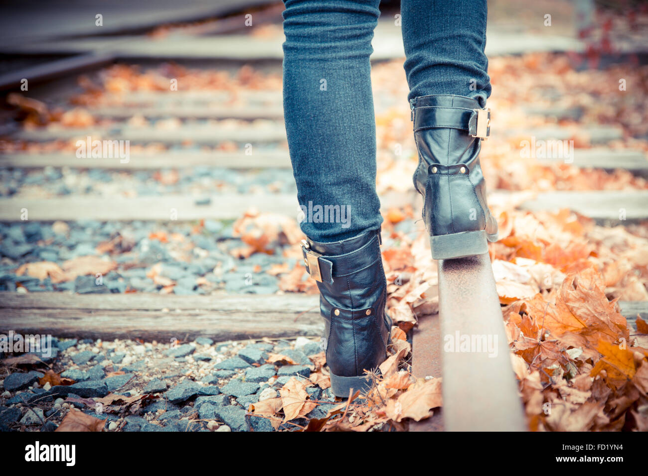 Botas de cuero negro a lo largo de antiguas vías del ferrocarril. Imagen en  tonos Vintage Fotografía de stock - Alamy