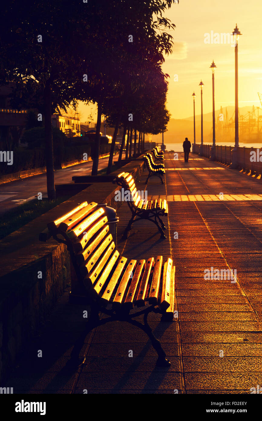 Lonely persona caminando al amanecer. Foto de stock