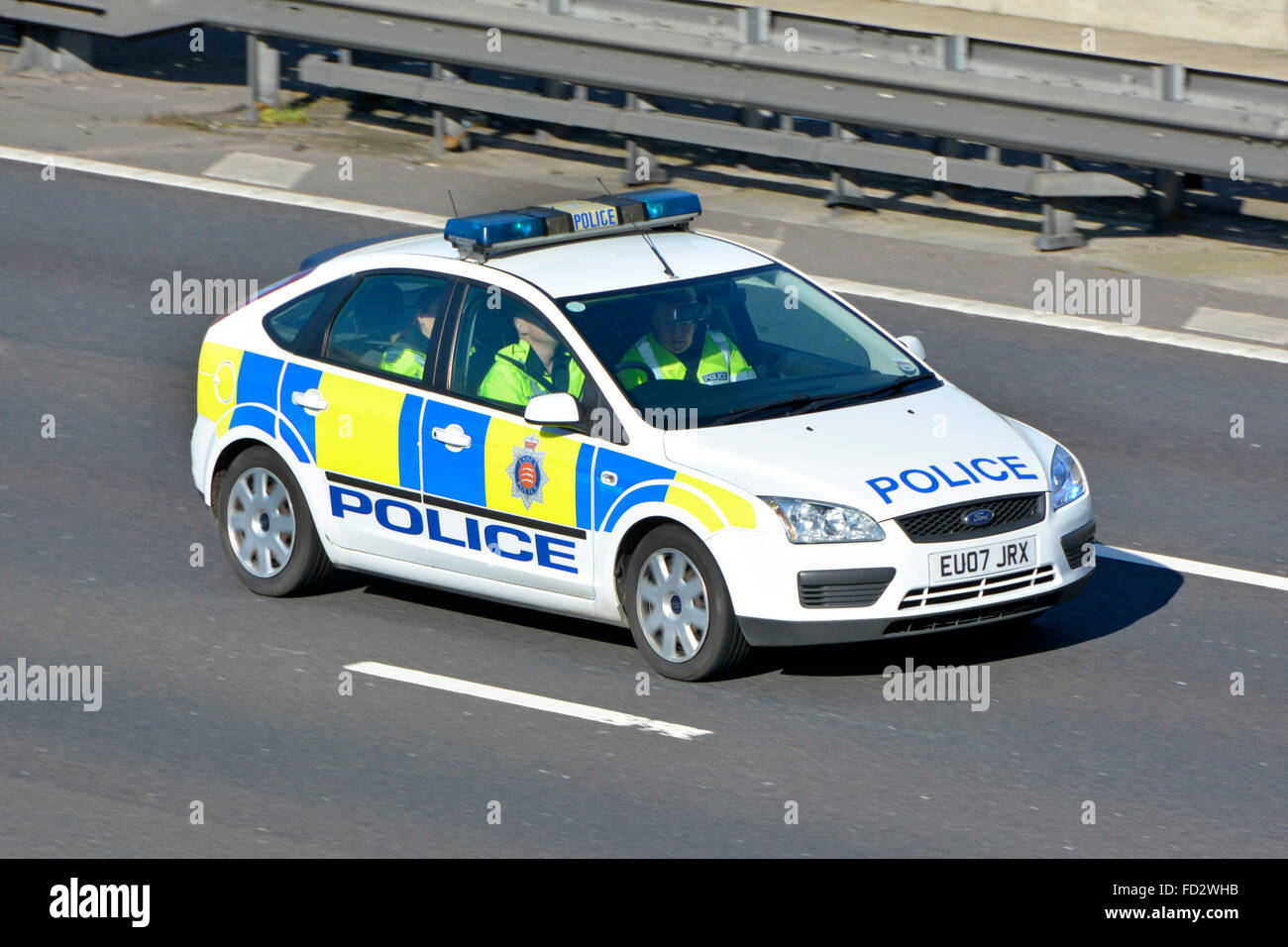 Grupo de oficiales en Essex coche de la policía que conduce a lo largo de la autopista M25 con luces azules en posiblemente entrenamiento de conductores de la base cercana Essex Inglaterra Reino Unido Foto de stock