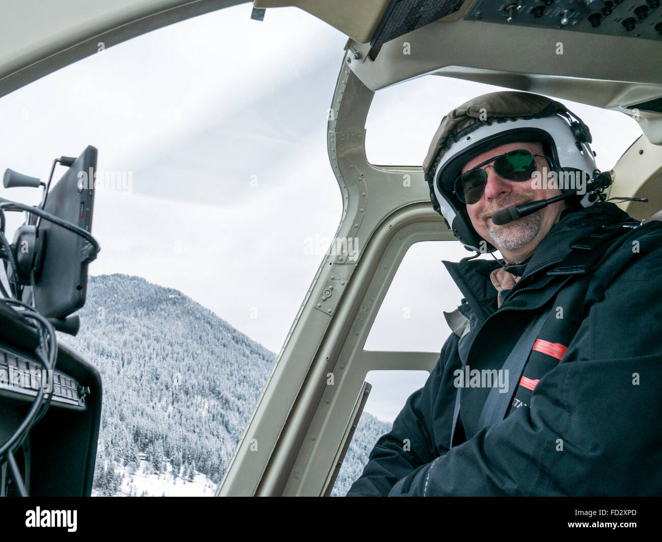 Piloto de helicóptero volar de regreso a país esquiadores en Selkirk montañas cerca de montaje remoto Lodge Carlyle, British Columbia, Canada Foto de stock