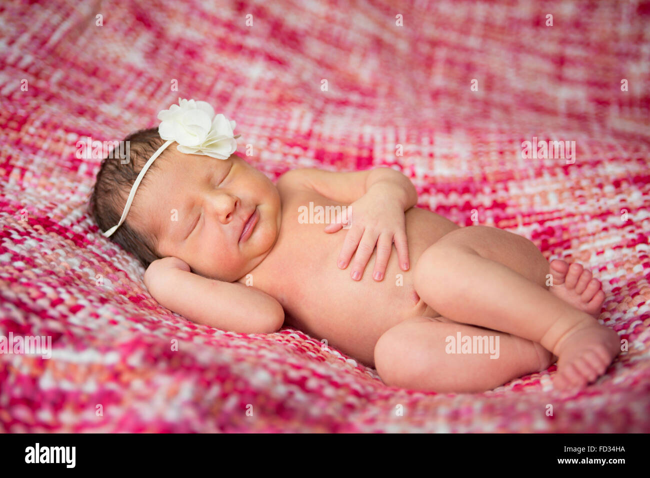 Fotos de Bebé recién nacido niña en manta rosa acostado en la