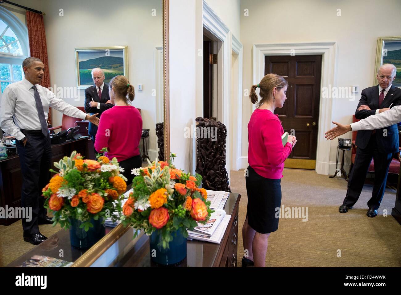 El presidente estadounidense Barack Obama se refleja en el espejo cuando habla con Amy Rosenbaum, Asistente del Presidente para Asuntos Legislativos, y el Vicepresidente en el exterior de la Oficina Oval de la Casa Blanca el 15 de junio de 2015 en Washington, DC. Foto de stock
