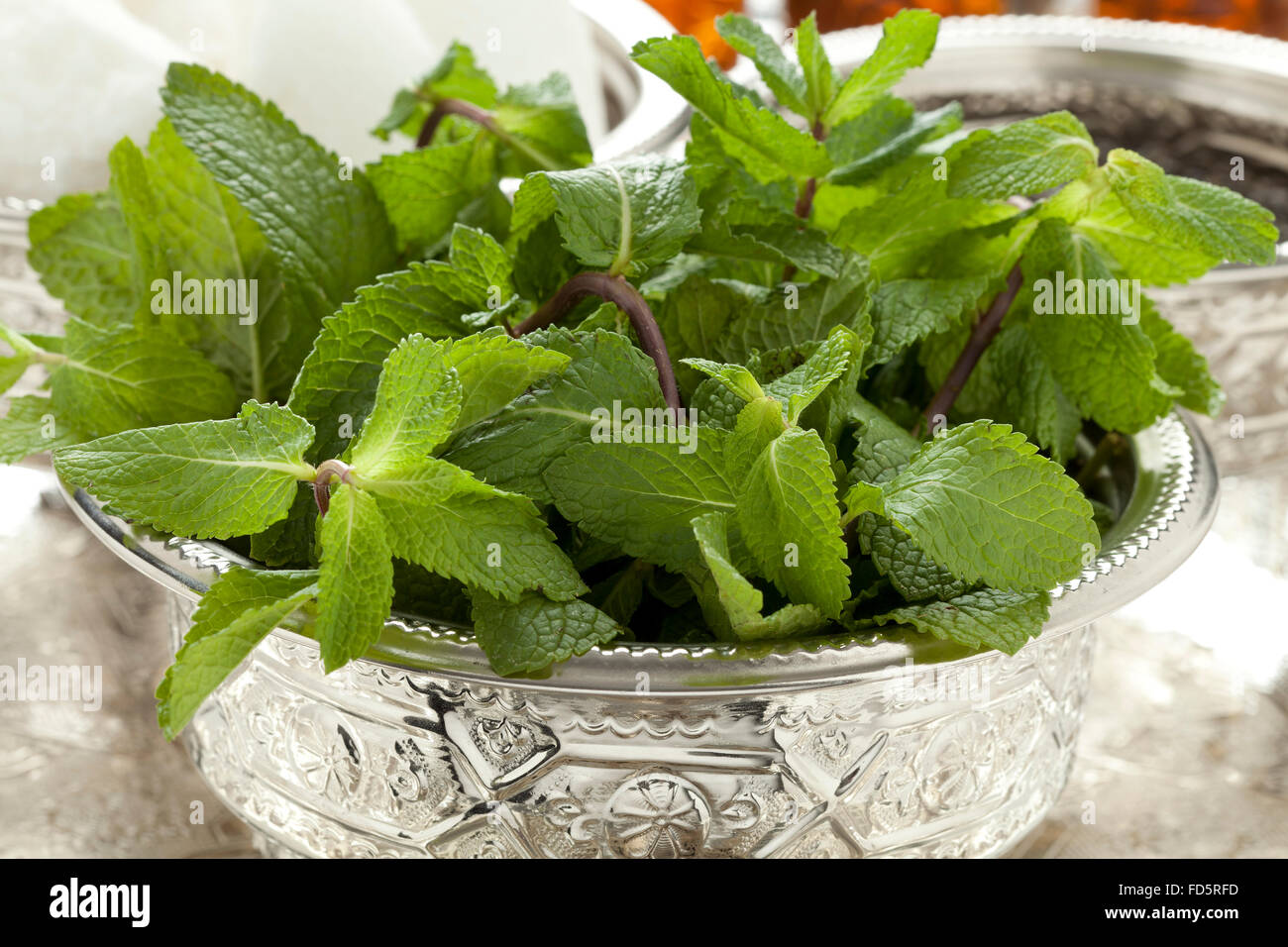 Recipiente tradicional marroquí con hojas de menta Foto de stock
