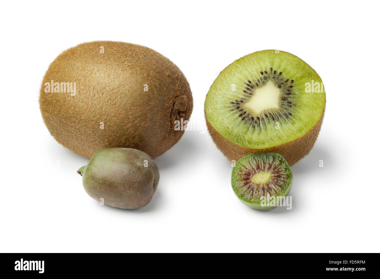 Entero y mitad kiwi y kiwi berry sobre fondo blanco. Foto de stock