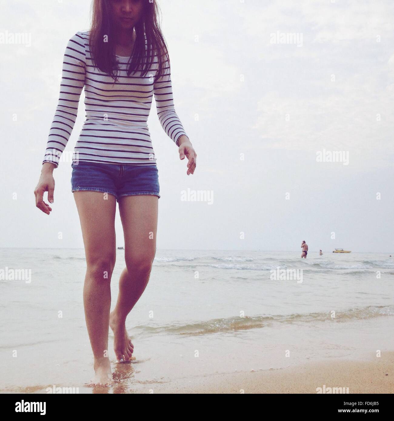 Mujer joven caminando en la playa Foto de stock