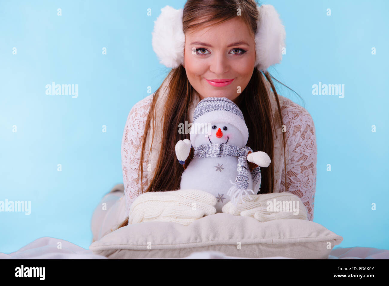 Niña del niño caucásico en ropa de invierno caliente y orejeras esponjosas  rosadas, sonríe a la cámara, construyendo muñeco de nieve al aire libre  Fotografía de stock - Alamy