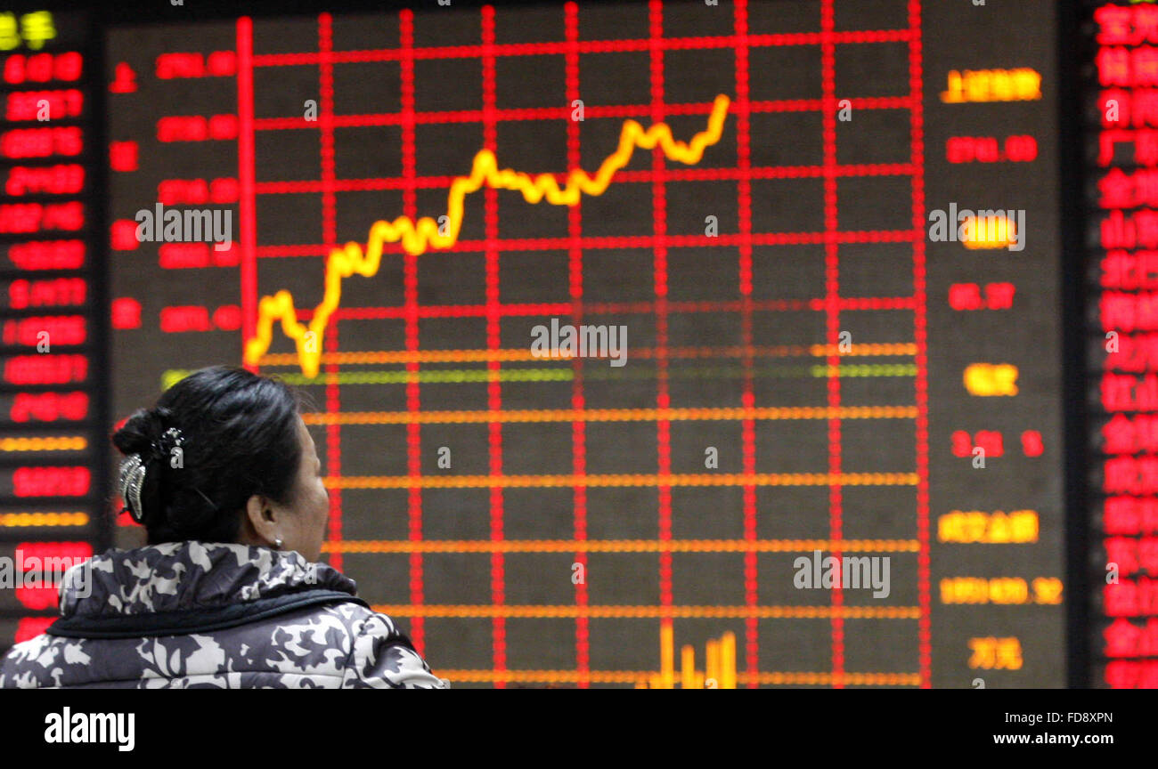 Huaibei, la provincia de Anhui. 29 ene, 2016. Un inversor busca a través de la información de stock en una sala comercial de una empresa de valores, al este de la ciudad de Huaibei en la provincia de Anhui, Enero 29, 2016. Las existencias de China cerró al alza el viernes, con el Índice Compuesto de Shanghai benchmark aumento de 3.09 por ciento a 2,737.6 puntos. El menor índice de Shenzhen ganó 3,7% para cerrar en 9,418.2 puntos. El ChiNext Index, que rastrea el NASDAQ China-style junta del crecimiento de las empresas, aumentó 4.6 por ciento para cerrar en 1,994.07 puntos. © Xie Zhengyi/Xinhua/Alamy Live News Foto de stock