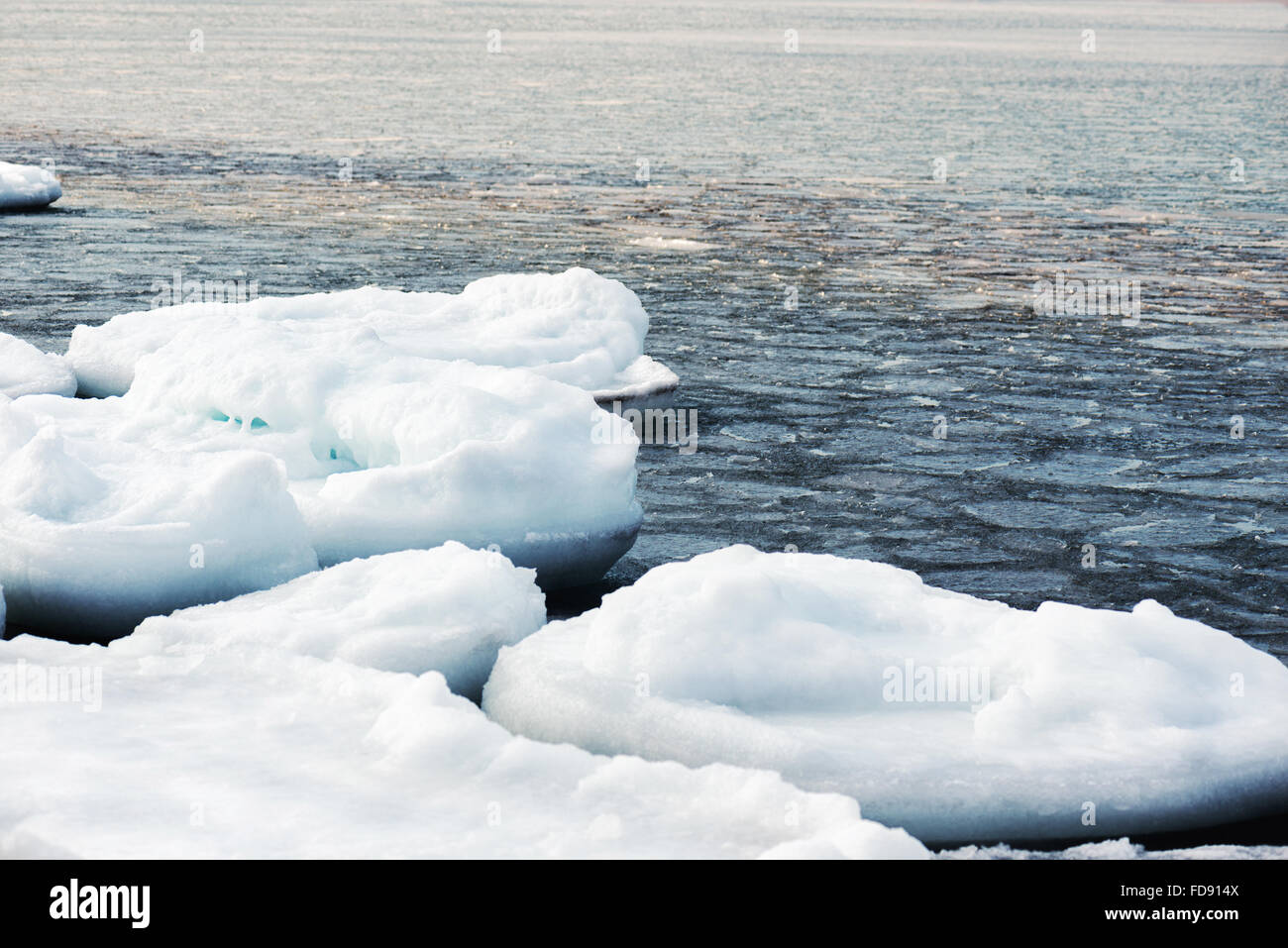 Bloques de hielo natural de mar rompiendo contra la orilla de congelación y el hielo durante el invierno. Naturaleza acuática del Ártico. Foto de stock