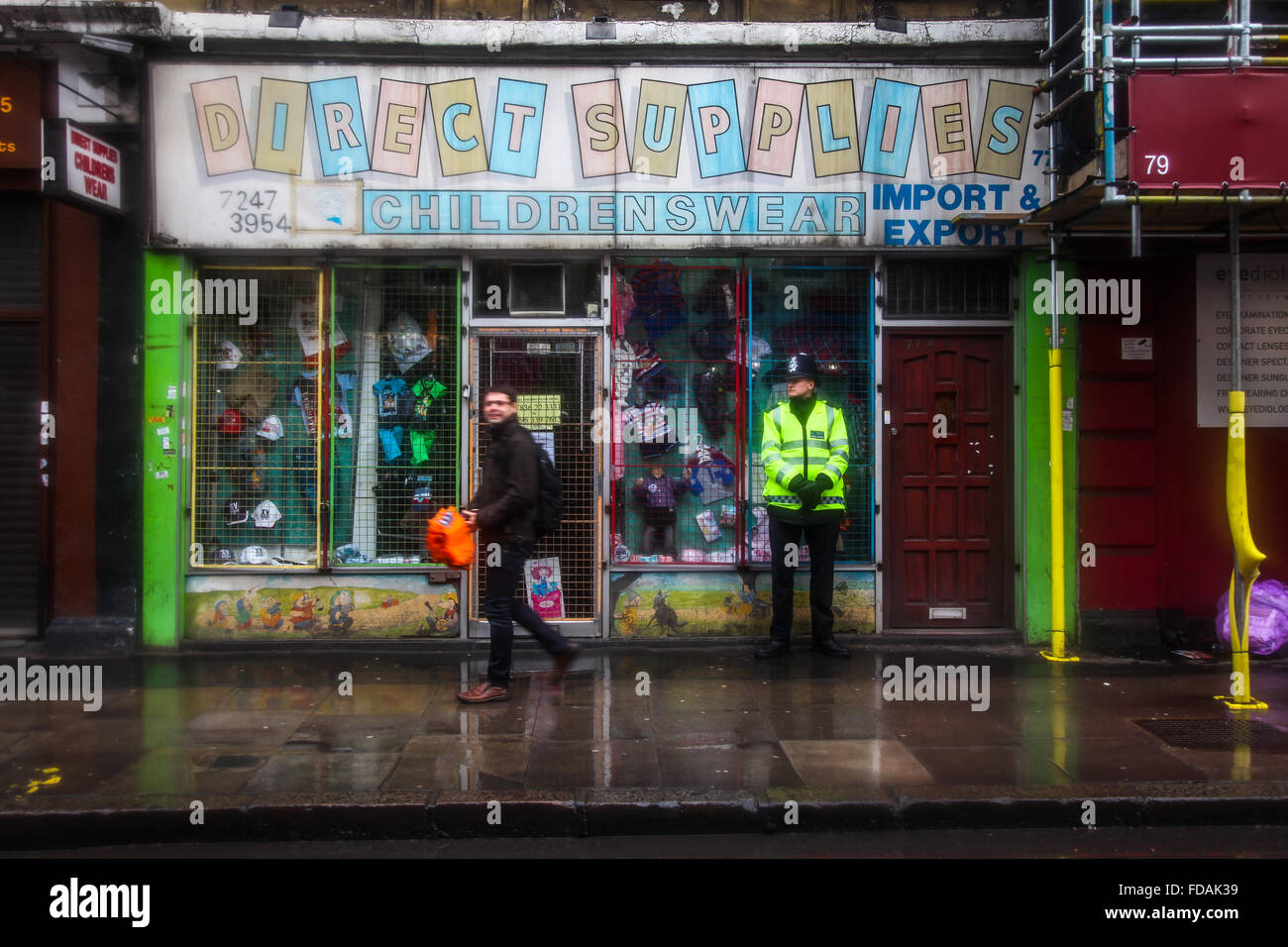La policía de peatones y hombre en frío húmedo día de invierno, East London Foto de stock