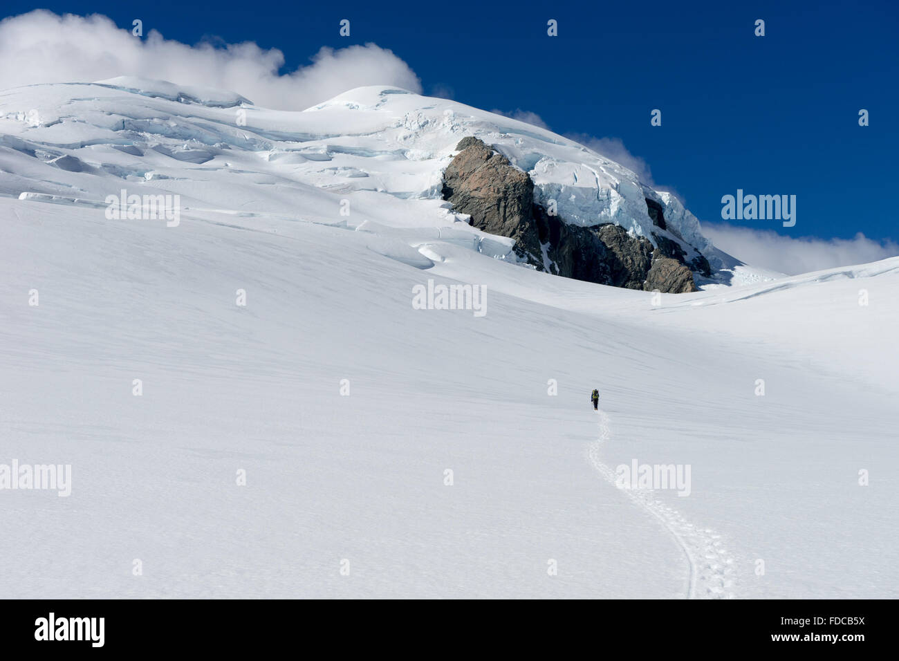 Hombre caminando entre las nieves de las montañas de Nueva Zelanda Foto de stock