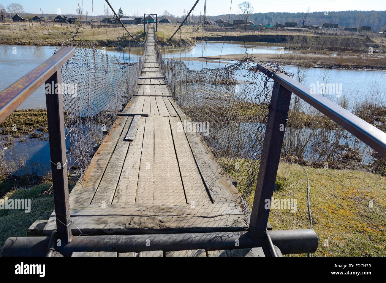 La suspensión del puente peatonal cruzando el río, en la aldea de Chebula Verkh-Chebula, región Kemerovo, Siberia, Rusia Foto de stock