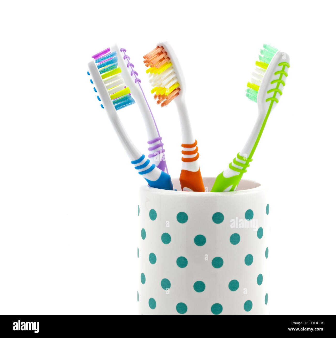 Él y Ella cepillos de colores en plástico soporte para vaso de precipitado  sobre los azulejos en el baño. Utilizado y signos de cepillos y pasta de  dientes en el vaso. Rojo