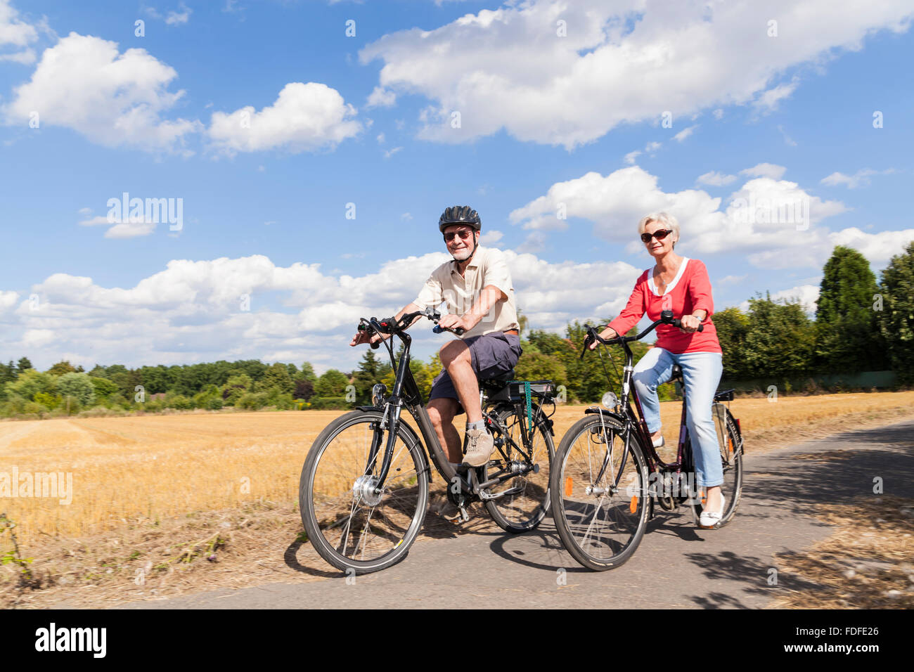 Personas mayores activas atractivo viaje en bicicleta en primavera verano otoño otoño Foto de stock