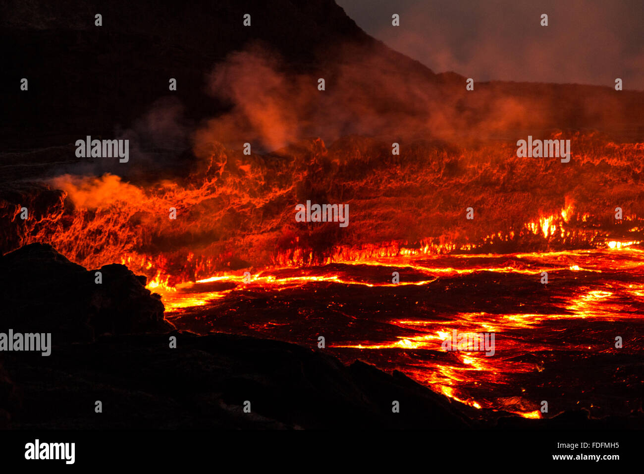 Las líneas rojas de hot lava muestran las grietas de la corteza delgada de lago de lava de Erta Ale Foto de stock