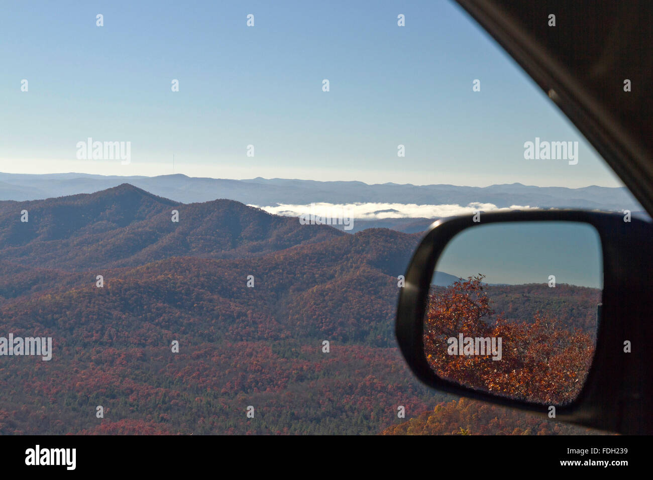 Ver a través de una ventana de coche y un retrovisor conductor del bosque cubierto de Blue Ridge Mountains en otoño colorido Foto de stock