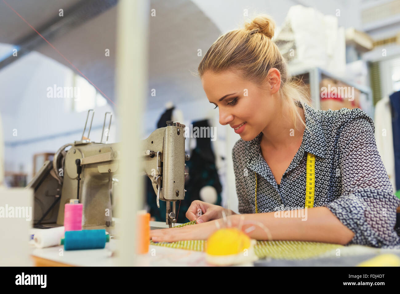 Mujer joven con máquina de coser Foto de stock