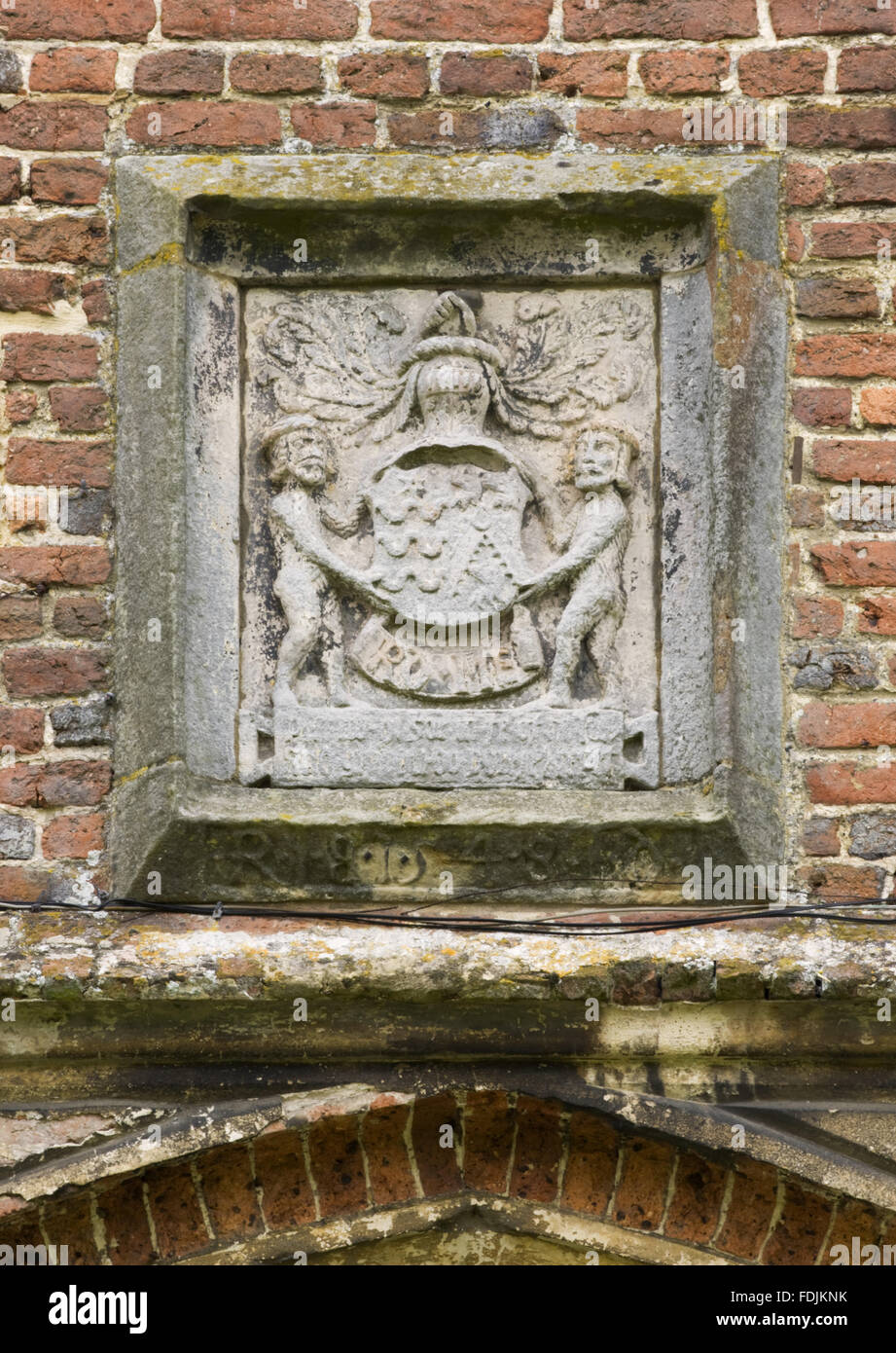 Un grupo escultórico de piedra con un escudo de armas flanqueado por figuras de operadora. Foto de stock