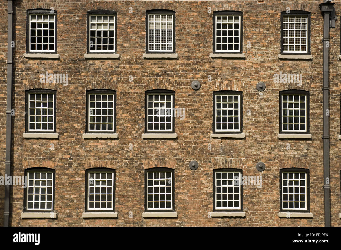 Fachada con filas de ventanas en Quarry Bank Mill, Styal, Cheshire. El molino fue fundada en 1784 y produjo el algodón hasta el 1950. Foto de stock