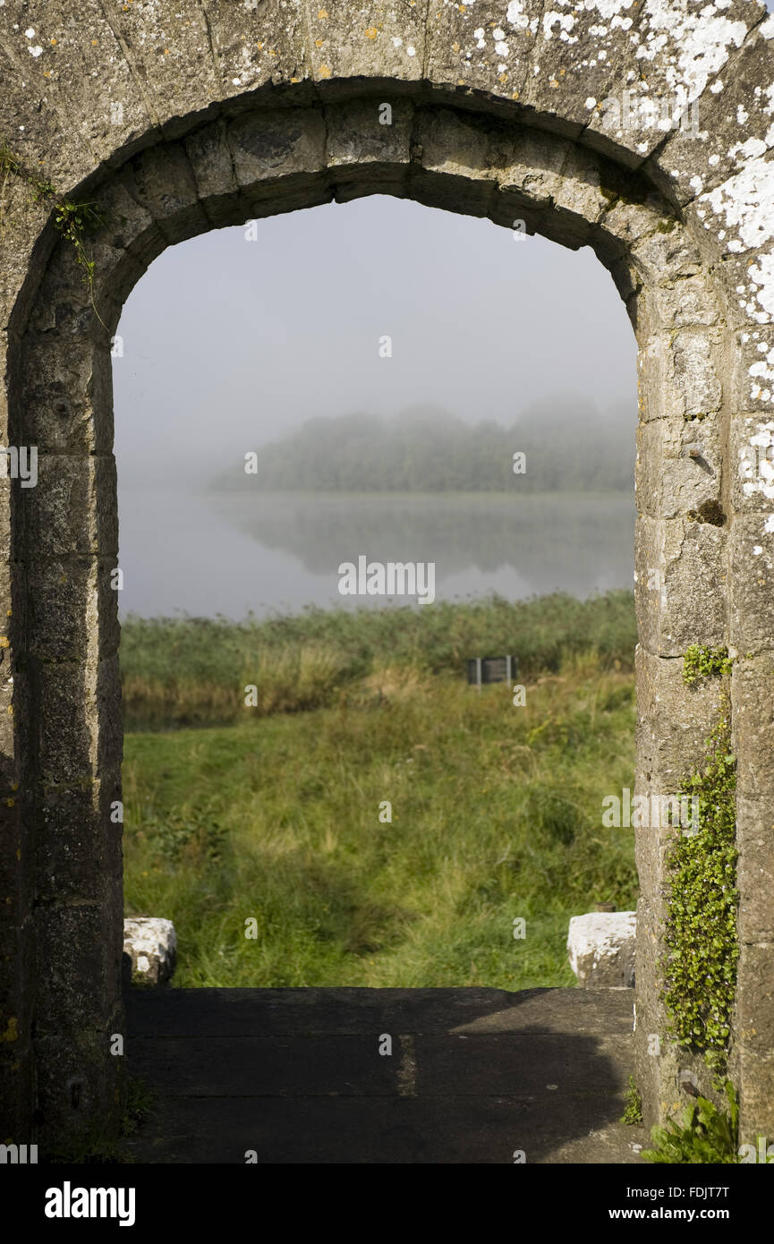 Vista a través de la arcada dooway de las ruinas de la antigua casa-torre en la orilla de Lough Erne a Crom, Co. de Fermanagh, Irlanda del Norte. Foto de stock