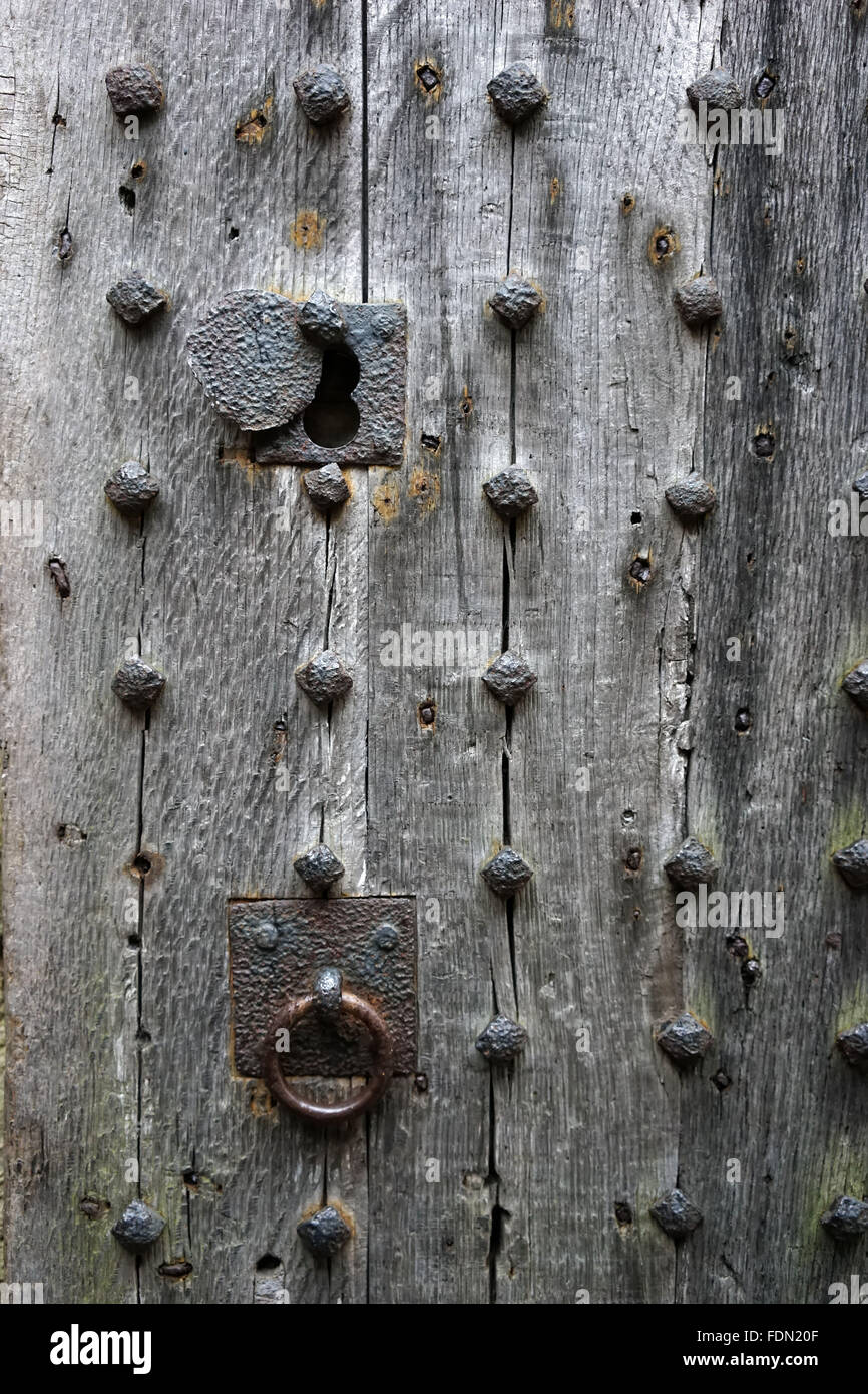 Una antigua puerta de madera con clavos oxidados con un bloqueo. Photo by Trevor Collens Foto de stock