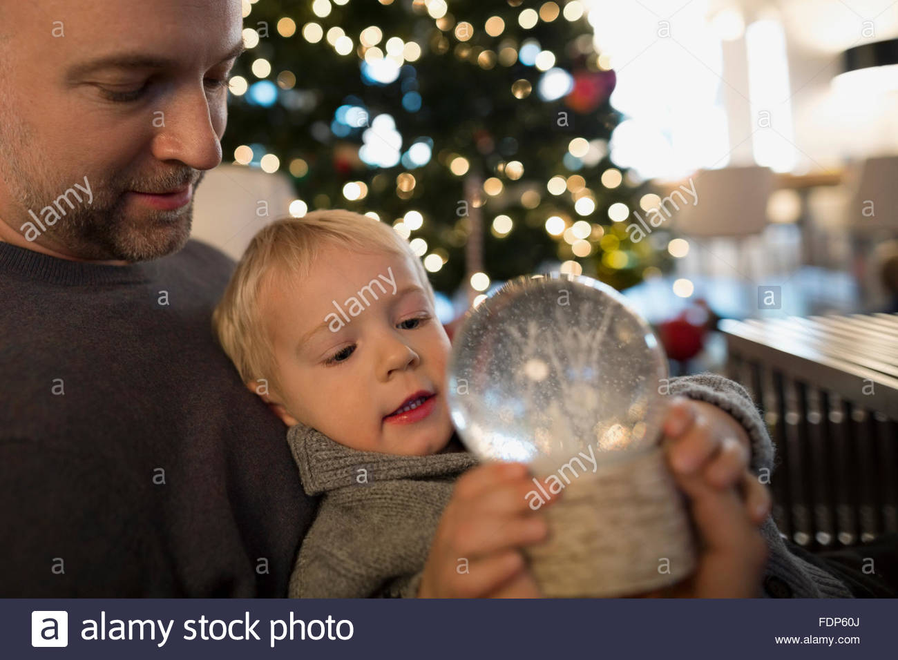Hijo de padre sosteniendo con snow globe Foto de stock