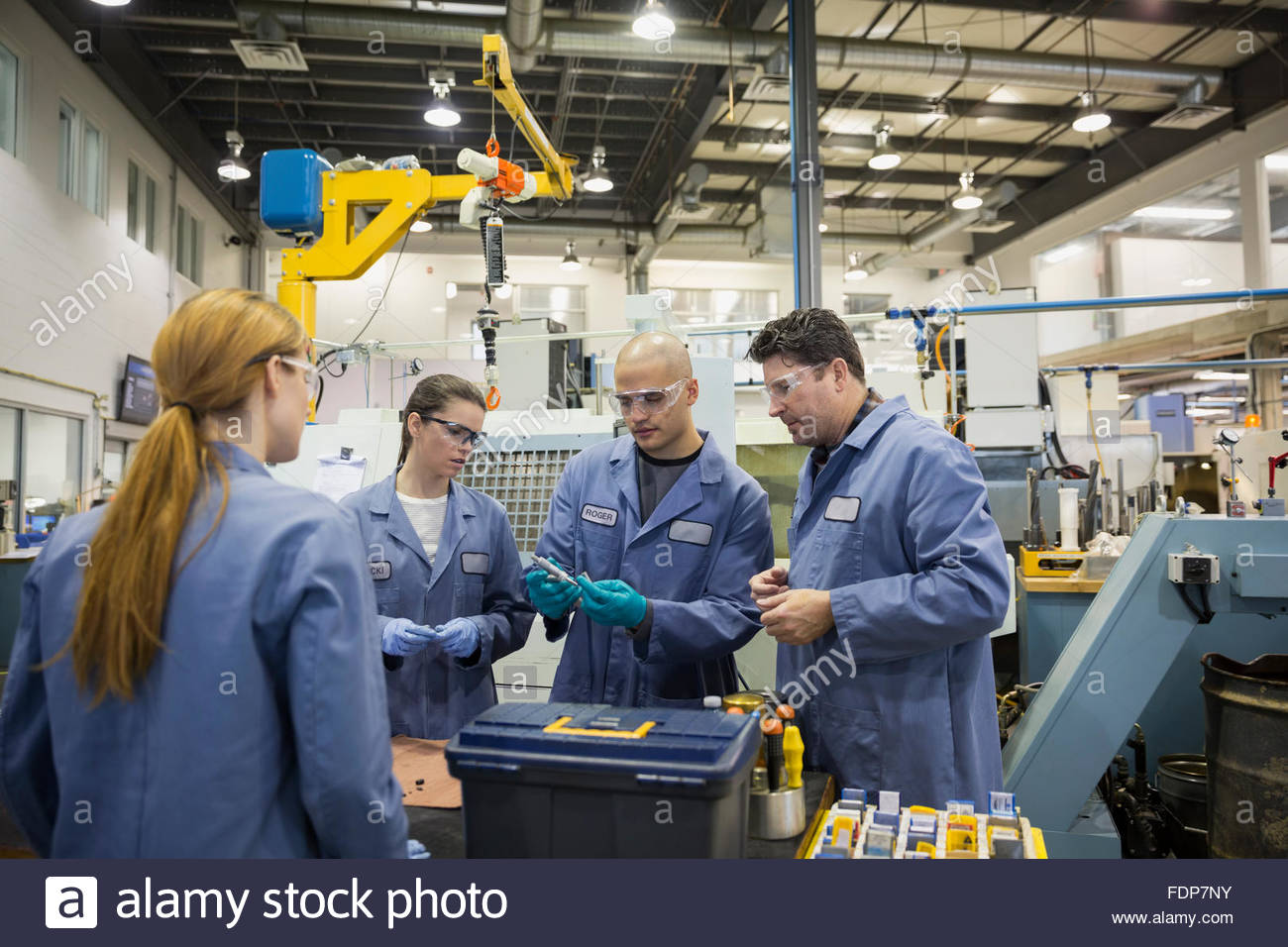 Los trabajadores examinar las piezas en la fábrica. Foto de stock