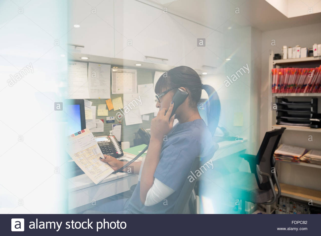 Enfermera hablando por teléfono en el centro de enfermería Foto de stock