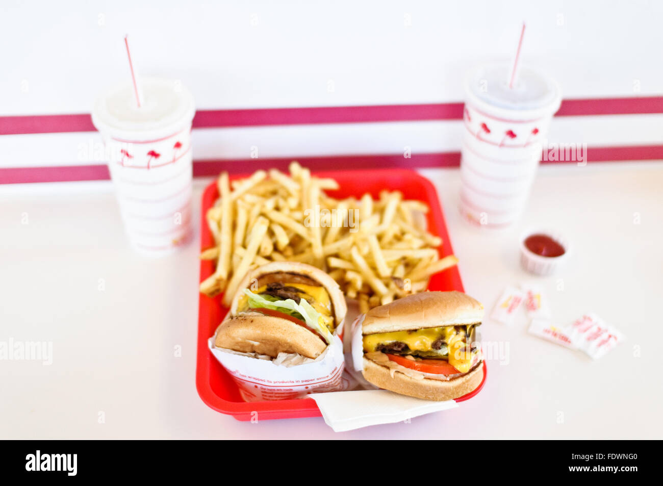 Una bandeja de hamburguesas con queso y papas fritas a la espera de ser comido en en-N-Out Burger, Los Angeles, California. Foto de stock