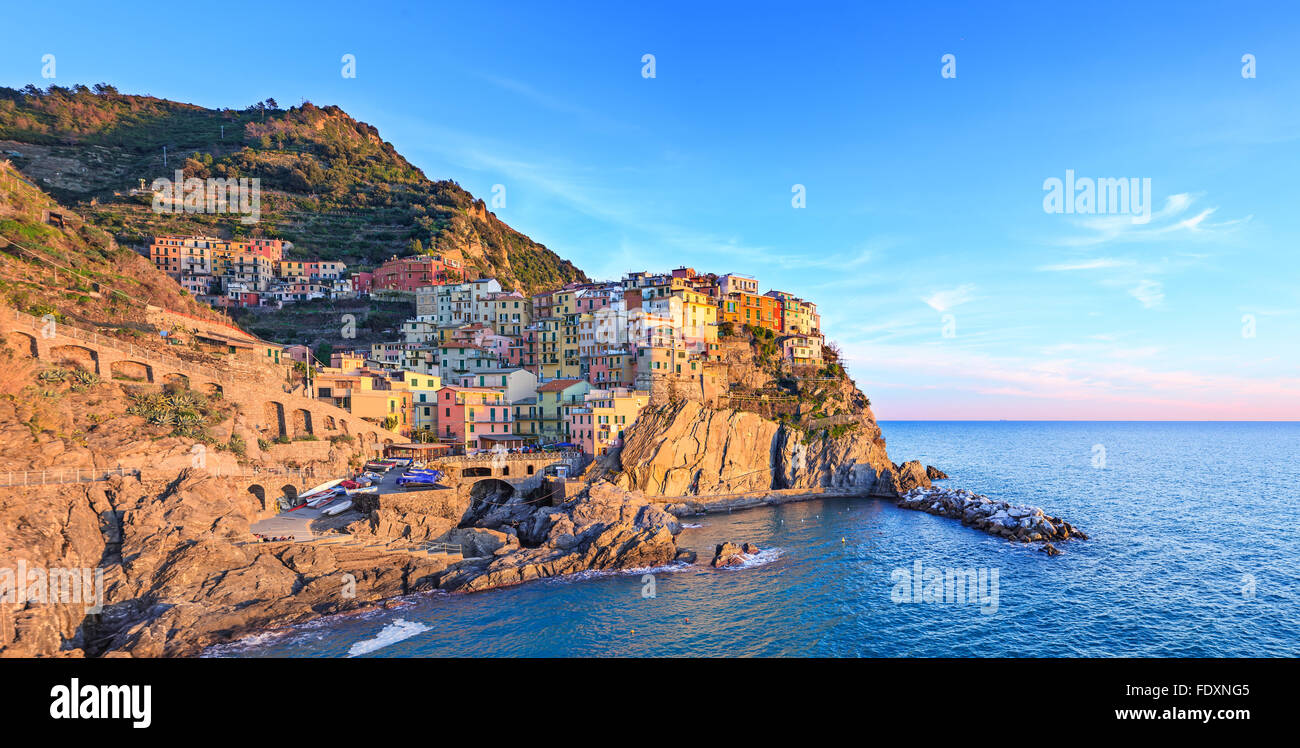 Manarola village sobre un acantilado de rocas y el mar al atardecer., Seascape en cinco tierras, el Parque Nacional de Cinque Terre, Liguria Italia Europa. Lo Foto de stock