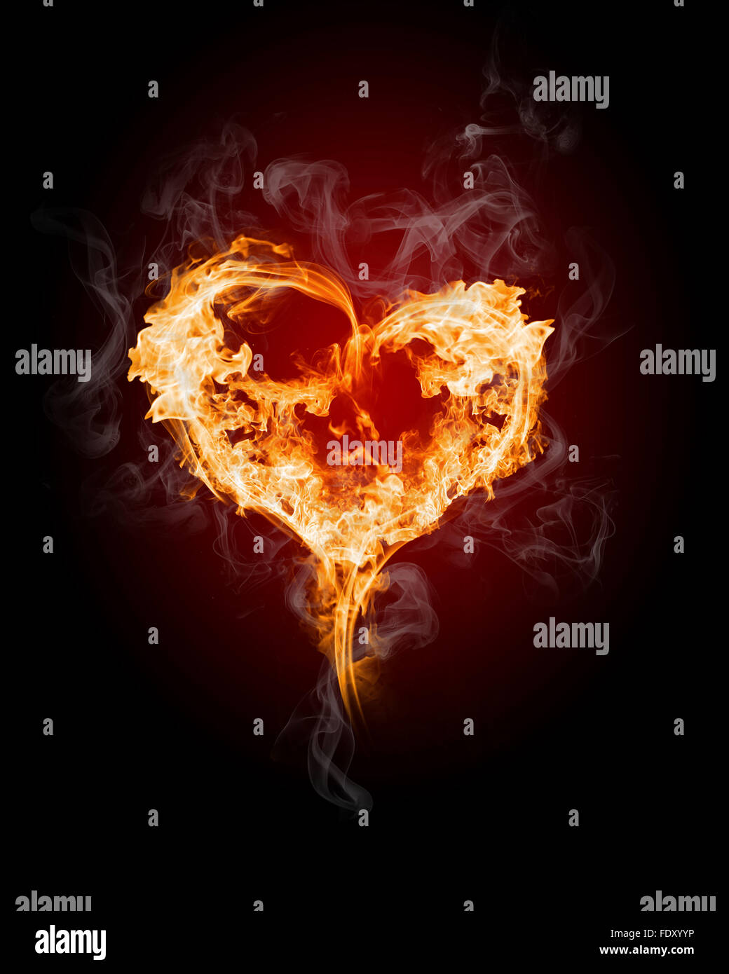 Corazón ardiente con llamas contra el fondo oscuro Foto de stock