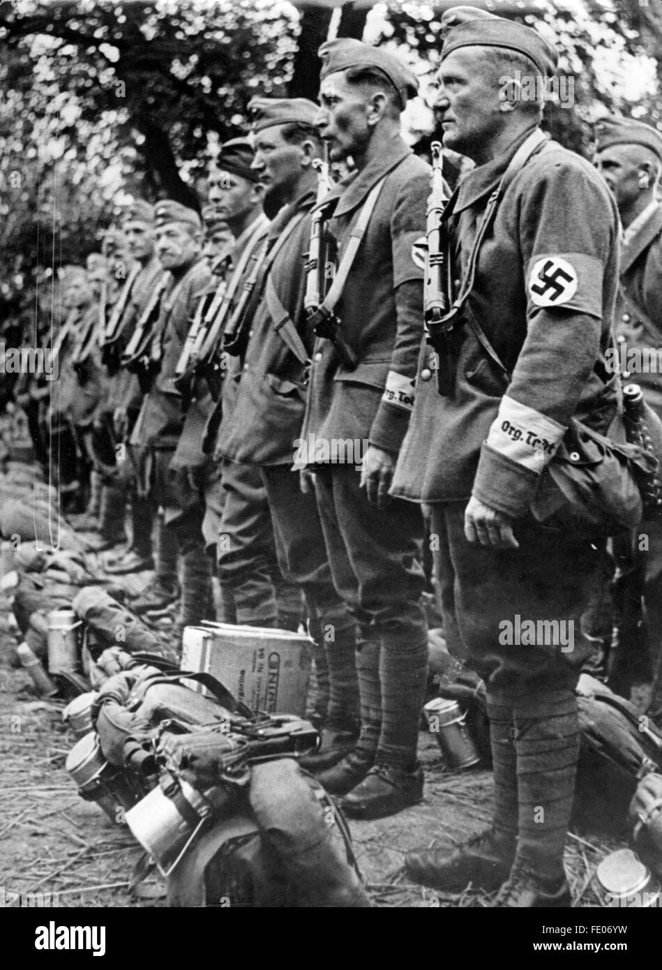 La imagen de la propaganda nazi muestra a miembros de la Organización Todt vistiendo uniformes con brazaletes esvásticos y letras en las mangas, así como armamento y mochila de campo. Ubicación y fecha desconocidas. Fotoarchiv für Zeitgeschichtee - SIN SERVICIO DE ALAMBRE - Foto de stock