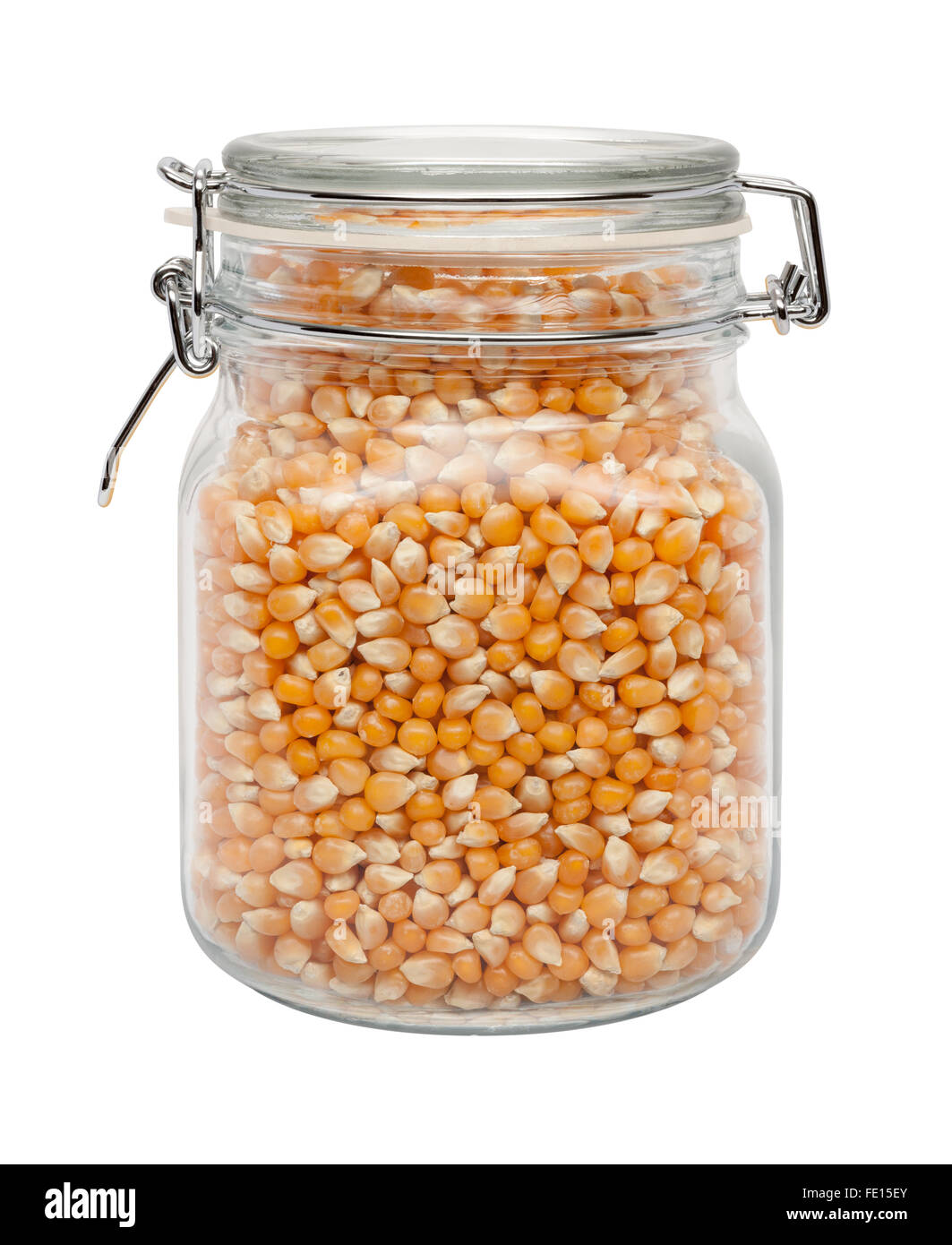 Palomitas de maíz sin cocer en un recipiente de cristal con una abrazadera metálica. La imagen es un recorte, aislado en un fondo blanco. Foto de stock