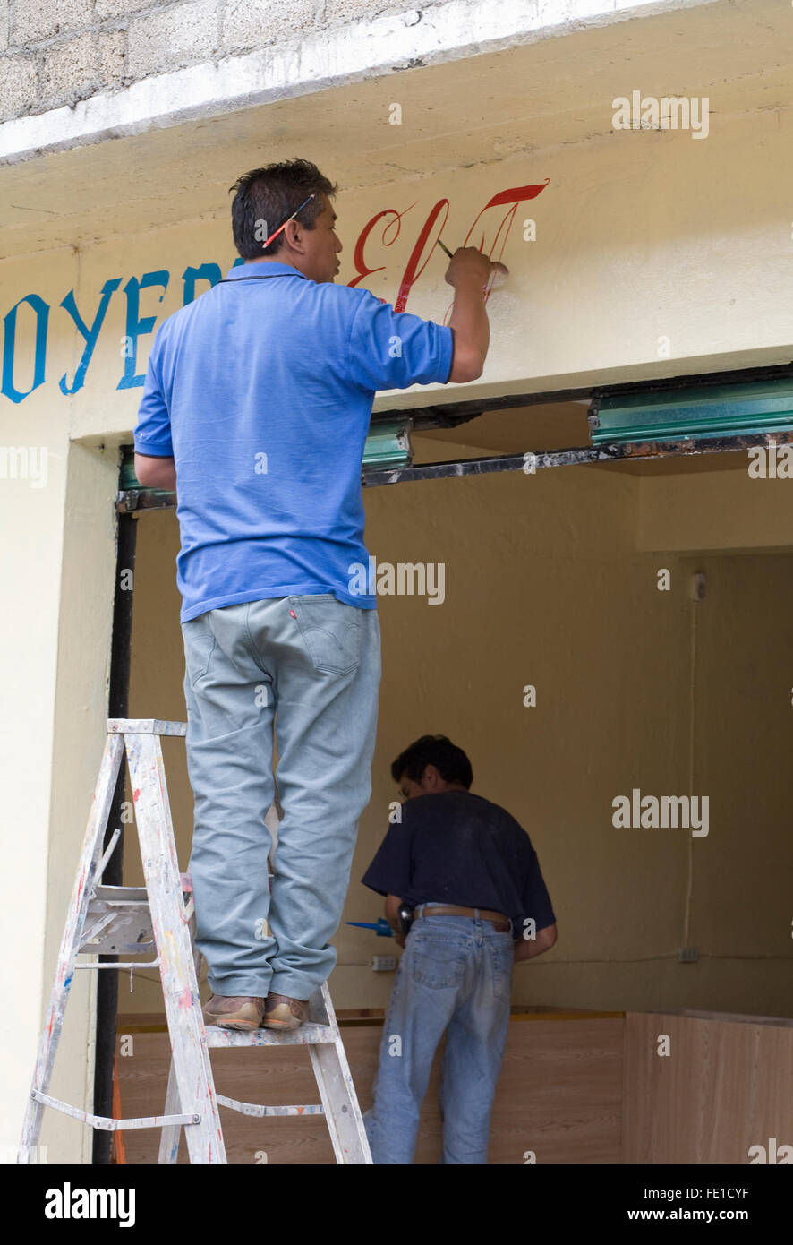 Hombre signo de pintura en la parte de una nueva tienda. Las pequeñas empresas en Oaxaca, México Fotografía de stock Alamy