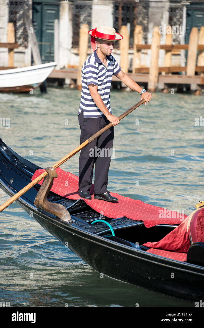 Un gondolero que llevaba su camisa a rayas azul y blanco y un boater con  una banda azul en Venecia, al norte de Italia Fotografía de stock - Alamy