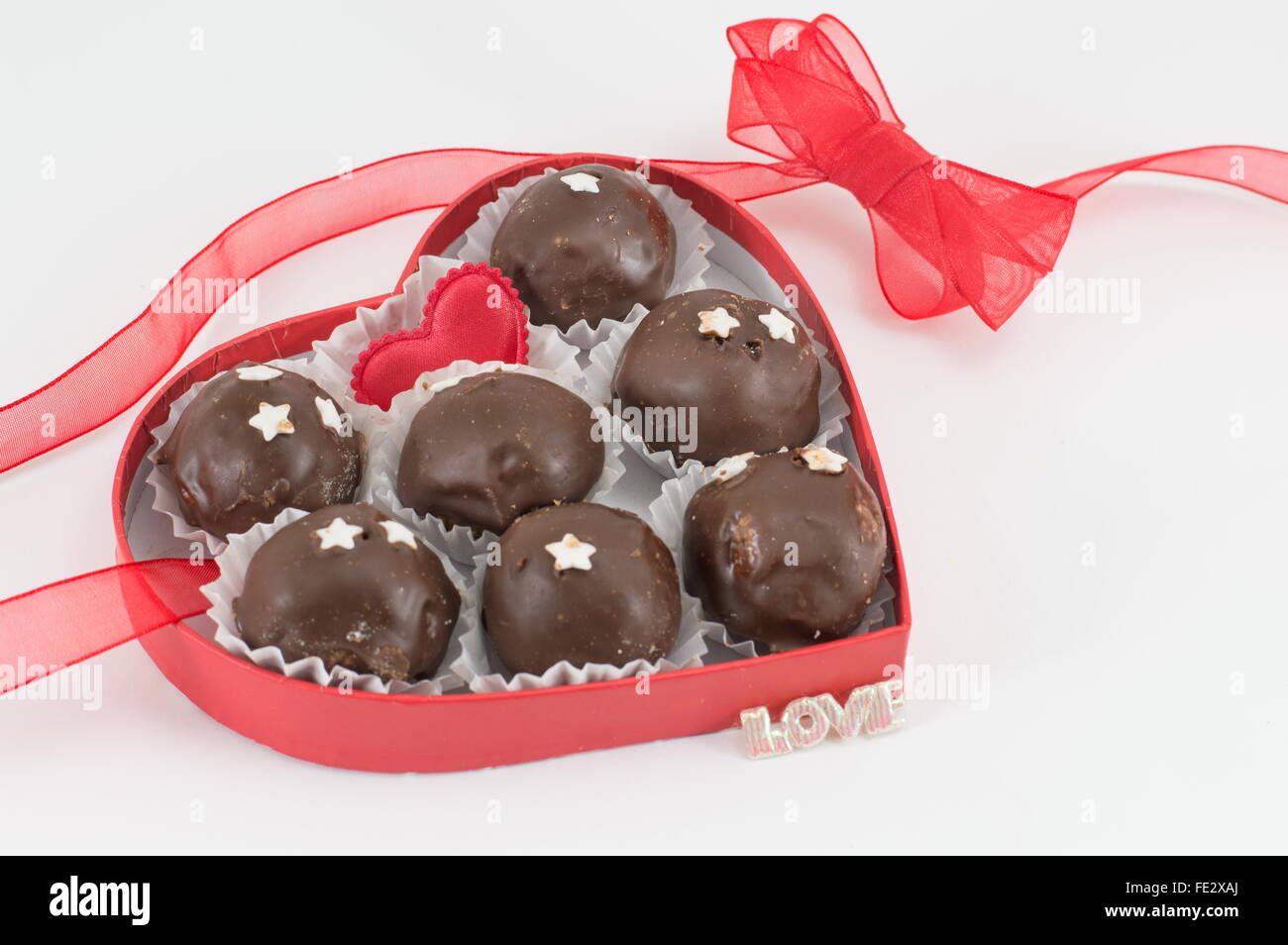 Galletas de chocolate en una caja en forma de corazón rojo Foto de stock