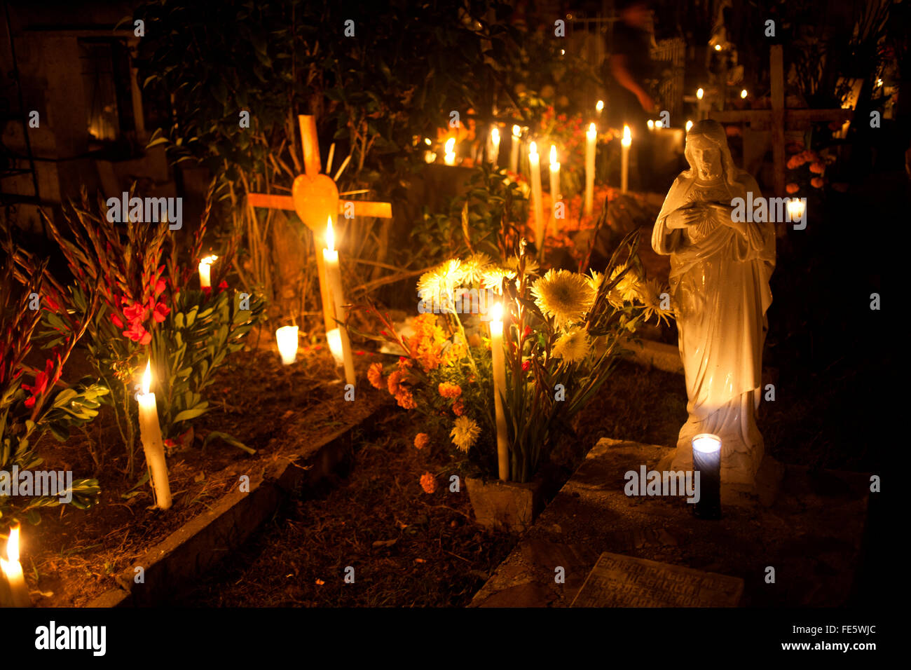 Velas y flores de caléndula amarilla, conocido como cempasuchil, y velas  decorar una tumba en el cementerio de San Gregorio Atlapulco Fotografía de  stock - Alamy