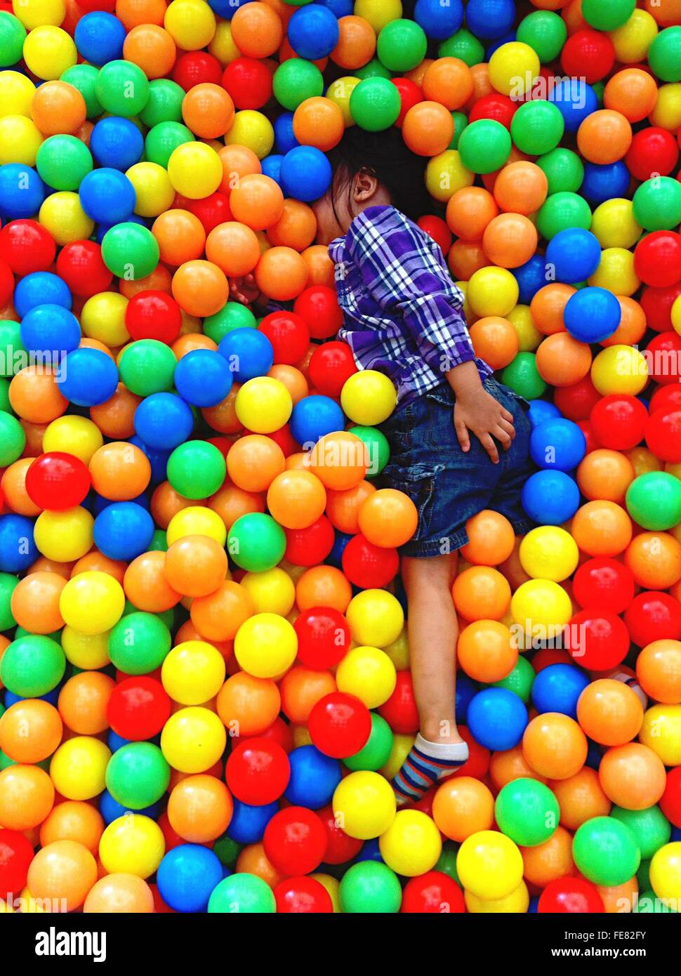 Un alto ángulo de visualización del niño jugando en la piscina de bolas Foto de stock