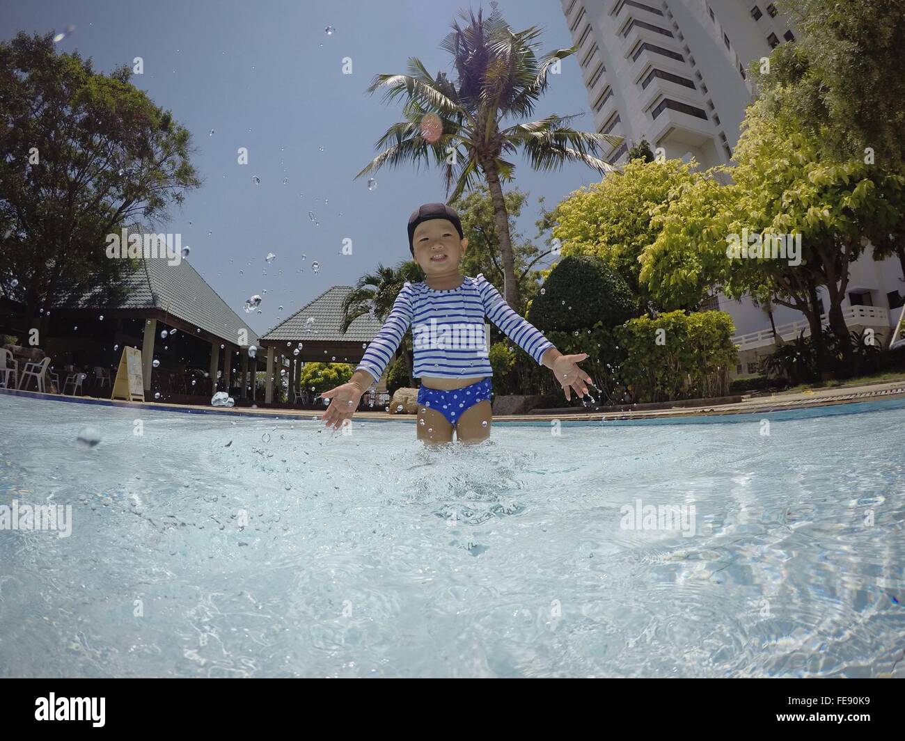 Chico saltando en la piscina Foto de stock