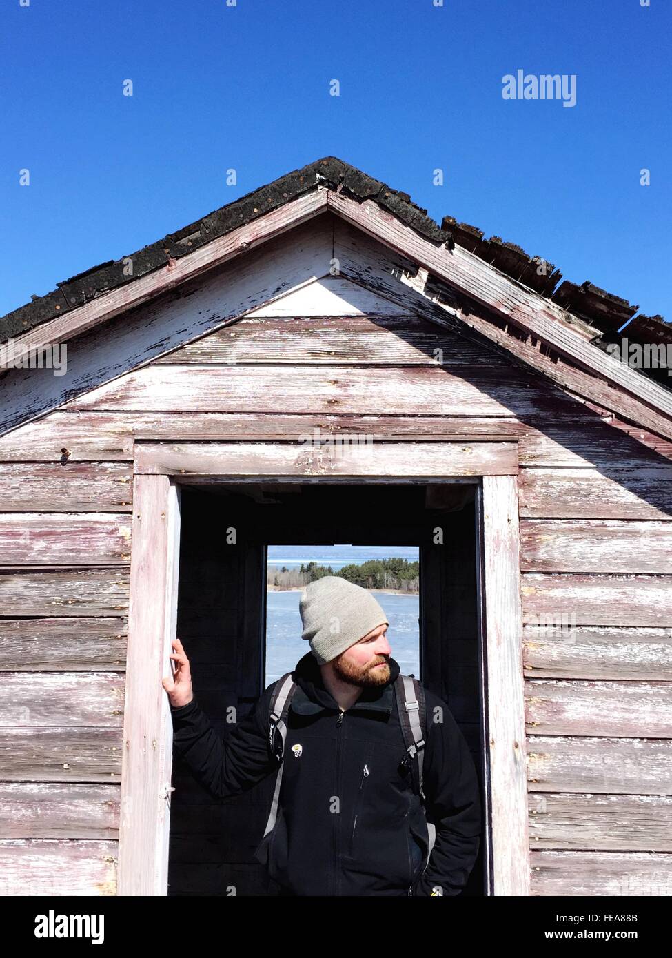 Hombre de pie en la puerta de la cabaña Foto de stock