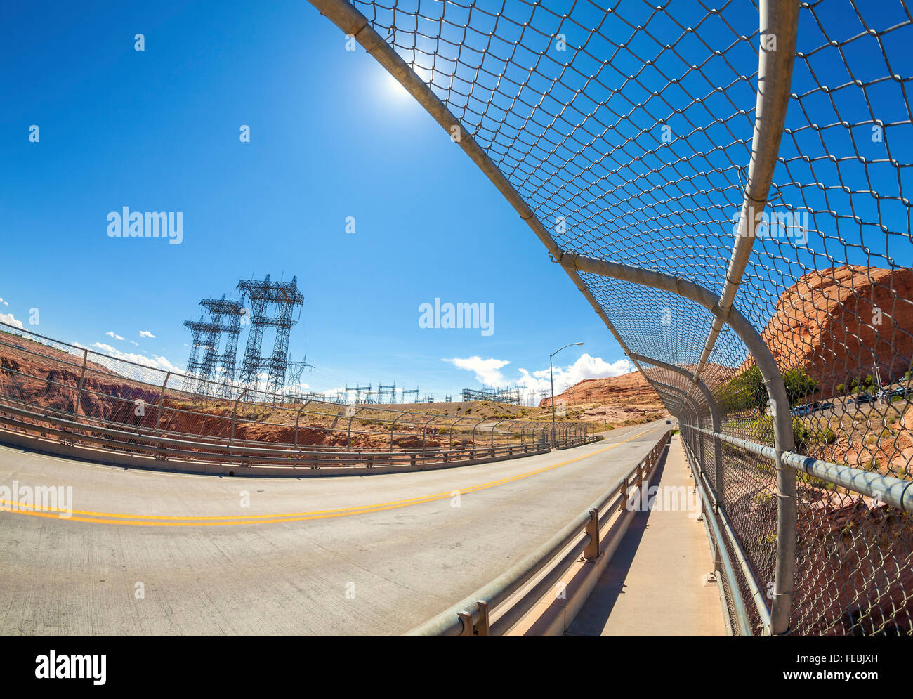 Lente ojo de pez foto de la carretera y la infraestructura de energía contra el sol, Glen Canyon Dam, Arizona, EE.UU. Foto de stock