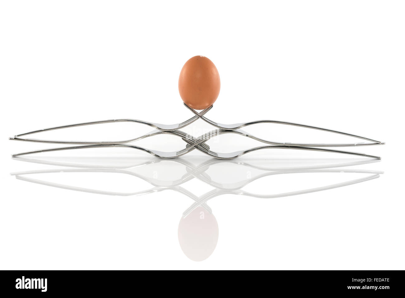 Equilibrio de huevo en seis horquillas aislado en blanco Foto de stock