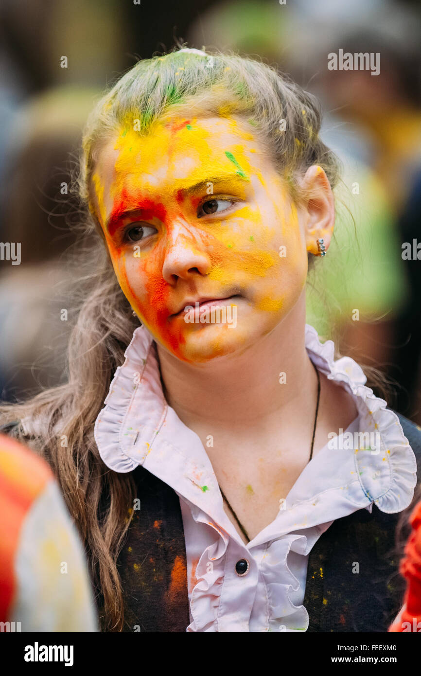 Hermosa joven con pintura en su cara mirando el festival de Holi de colores  en verano park en Gomel Fotografía de stock - Alamy