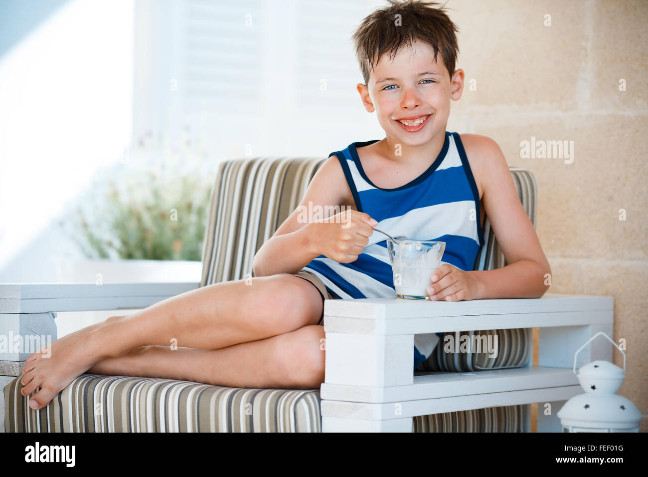 Niñito sonriente comer delicioso yogur Foto de stock