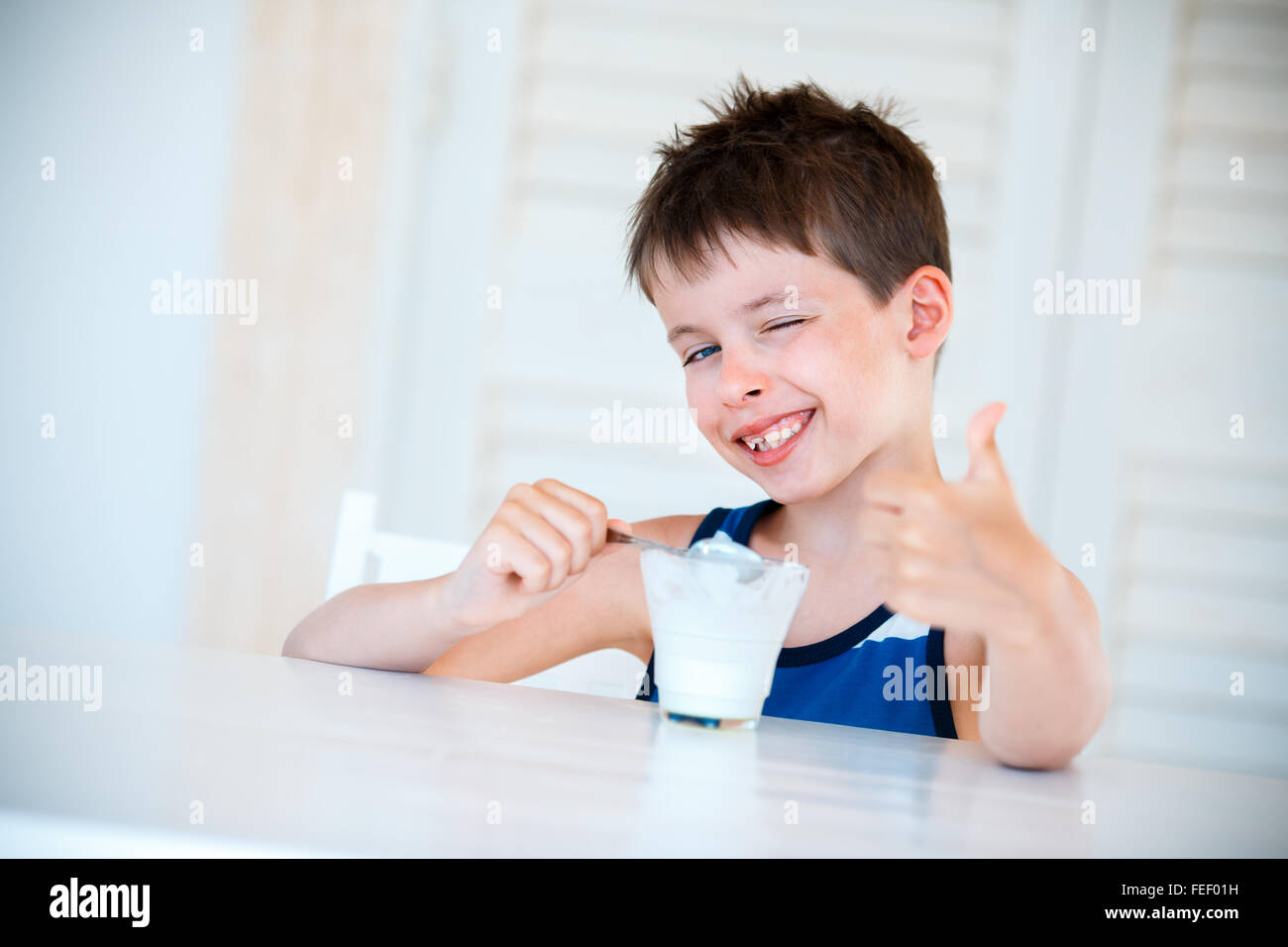 Niñito sonriente comer delicioso yogur Foto de stock