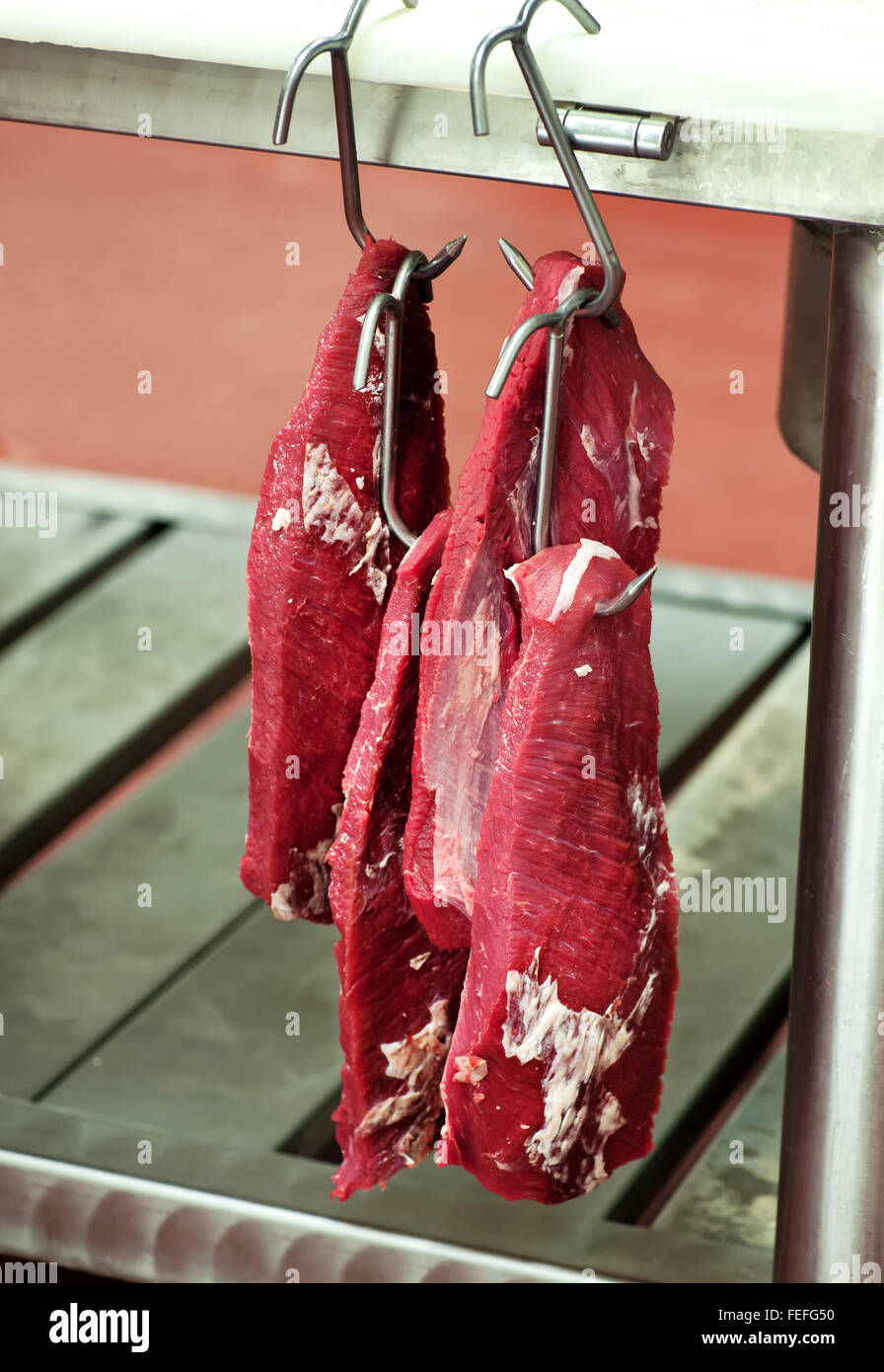 Filete de carne de vacuno magra filete recortado colgando en una carnicería de ganchos de carne Foto de stock