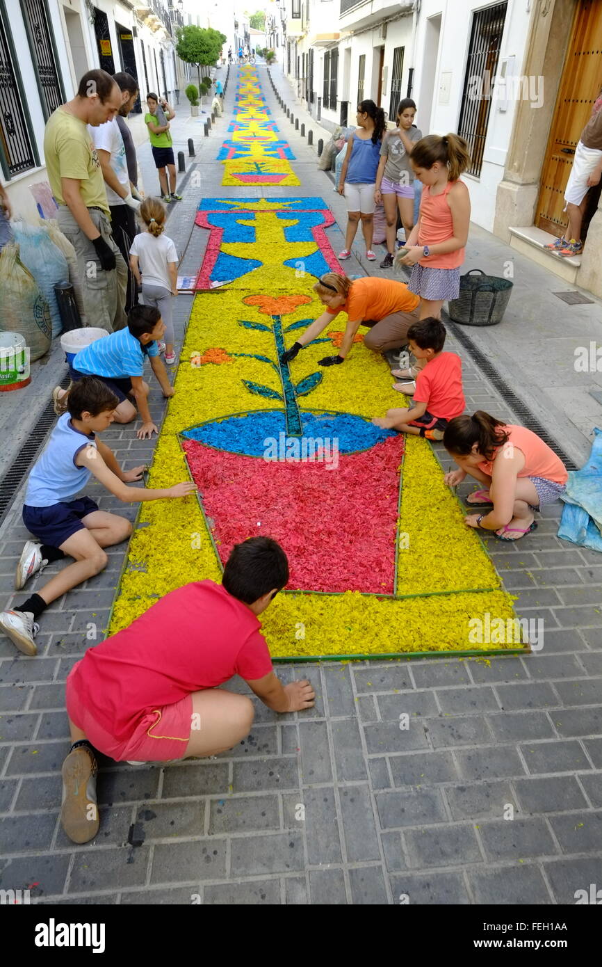 Corpus Christi. Aldeanos poniendo alfombras tradicionales de aserrín de  colores en su calle el Jueves Santo. Carcabuey, Andalucía, España  Fotografía de stock - Alamy