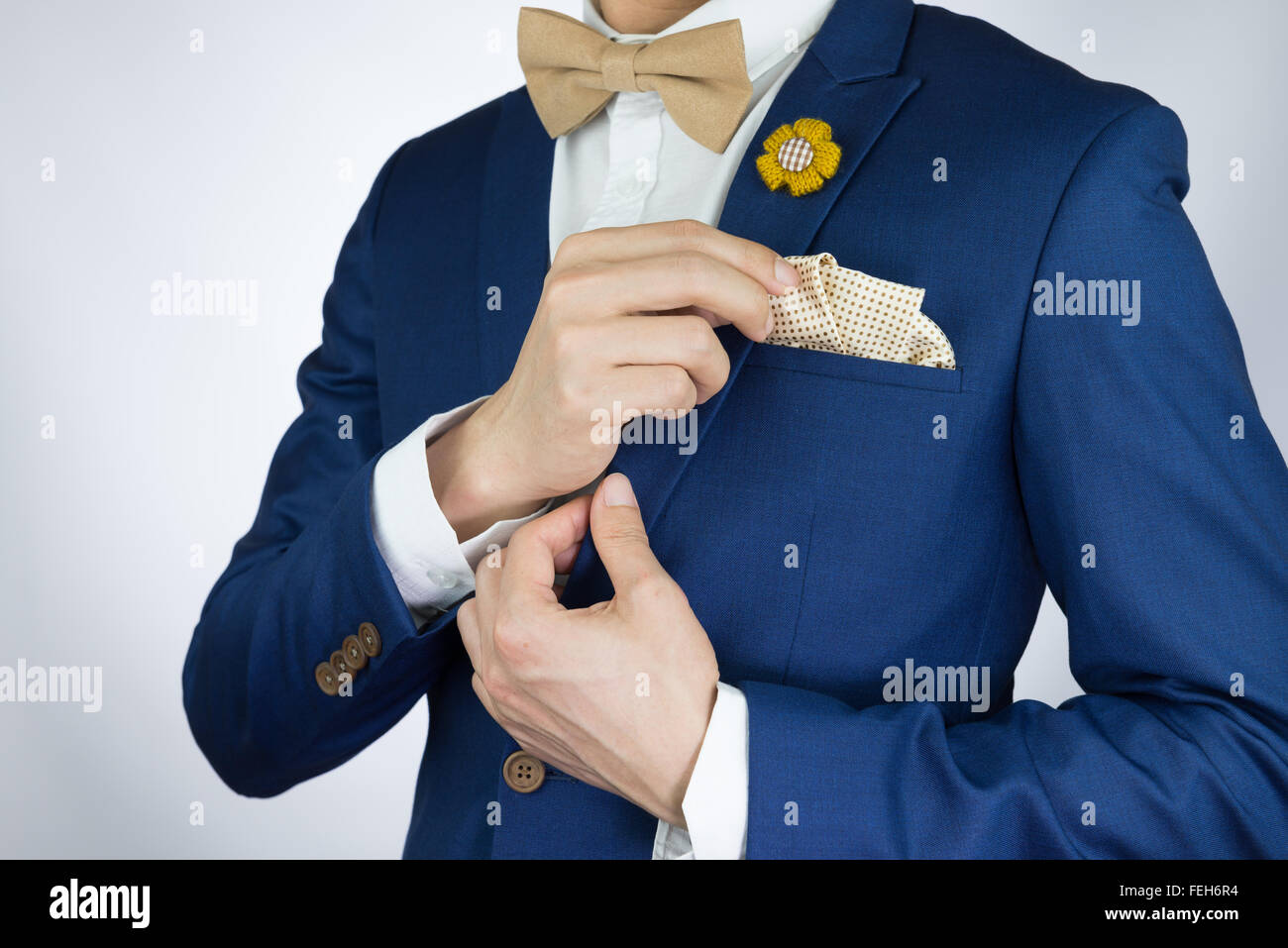 Hombre de traje azul con crema de café pajarita de color, broche de flor, y  el patrón de puntos cuadrados de bolsillo, cerrar Fotografía de stock -  Alamy