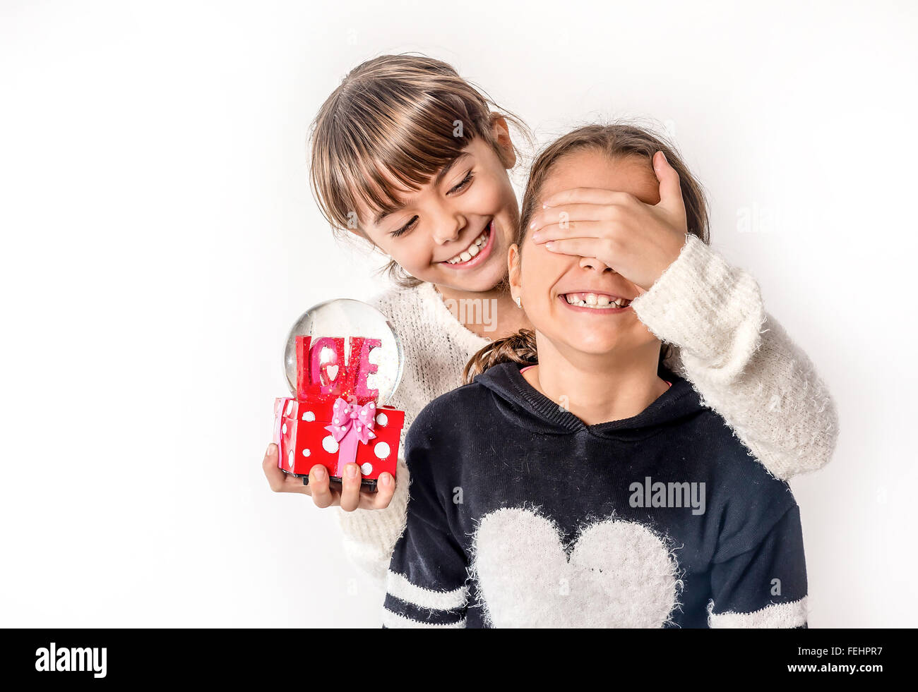 Niña dando amor regalo sorpresa a su amiga con fondo blanco Fotografía de  stock - Alamy