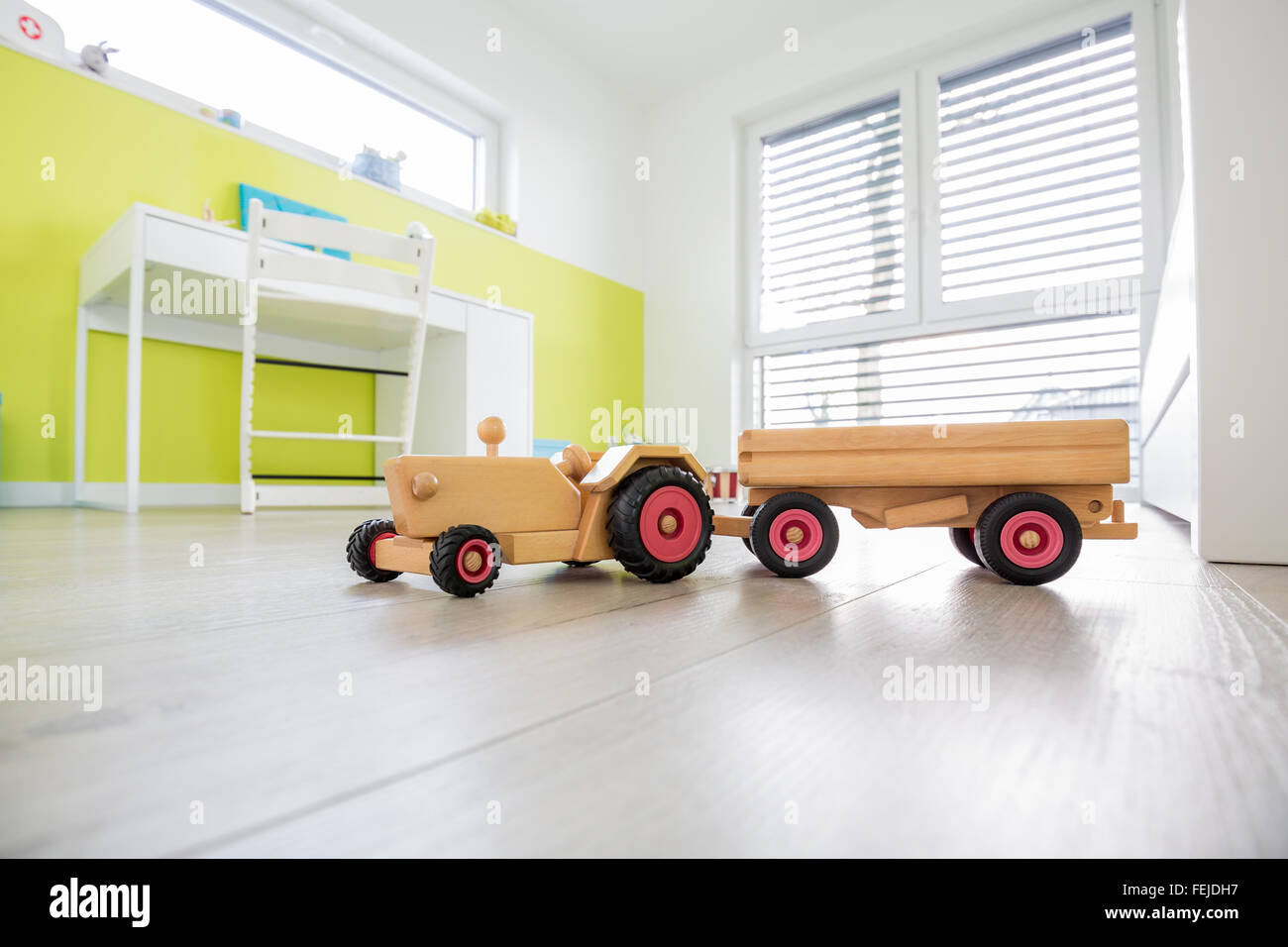 Colorida Sala de juegos para niños con escritorio y una pared verde con juguete en primer plano Foto de stock