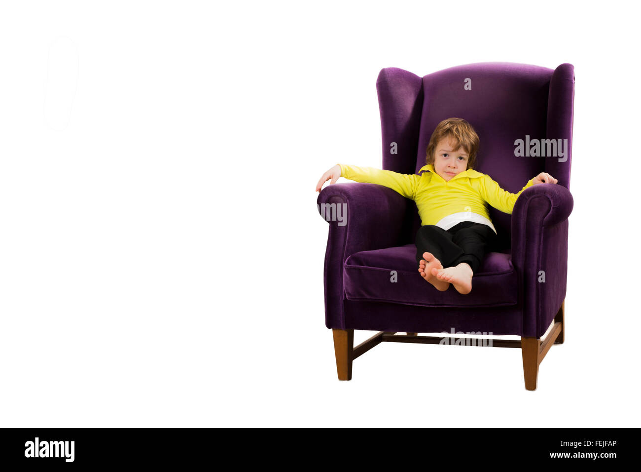 Pelo rojo aburrido muchacho sentado en el sofá morado sillón aislado sobre fondo blanco. Foto de stock